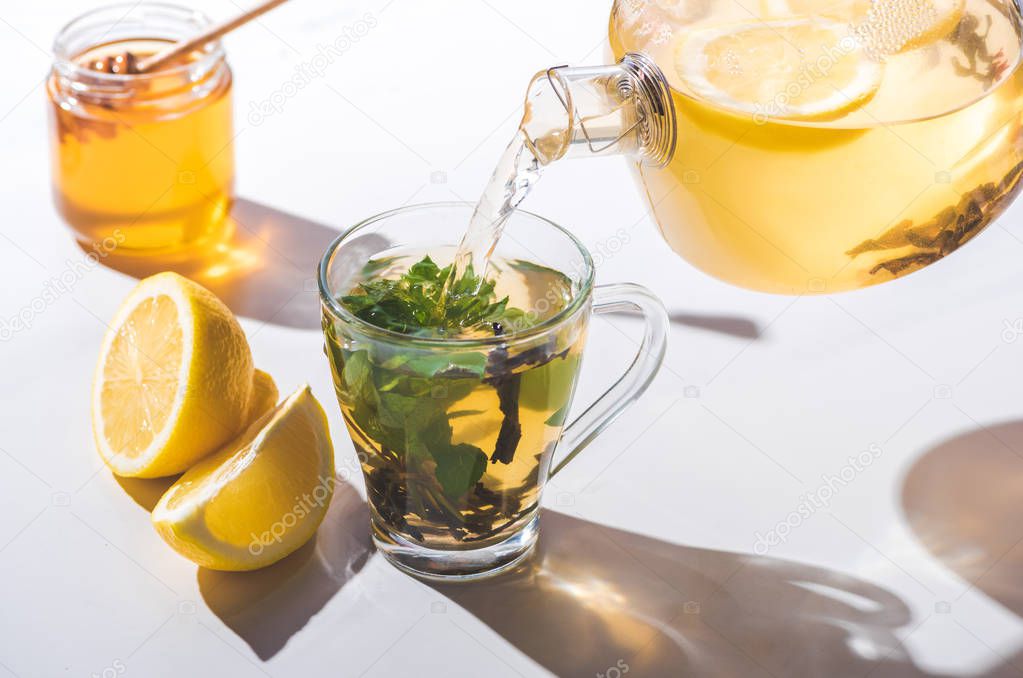 Taza de té con limón y miel al lado