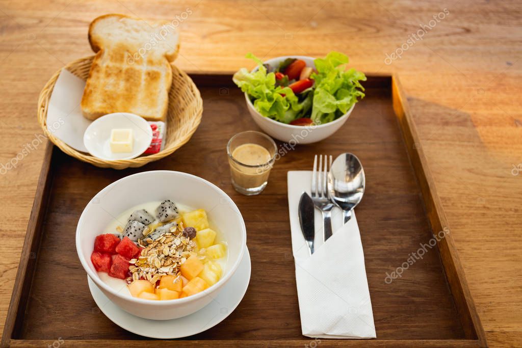 Desayuno con pan, fruta y miel sobre la mesa